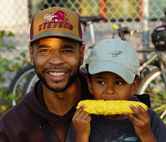 A father and son eating corn at the annual Willingdon corn roast 2024